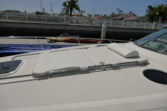 Slide: The Image of 2005 Sea Ray 340 Sundancer yacht deck with sun pad, docked near waterfront homes. - 36