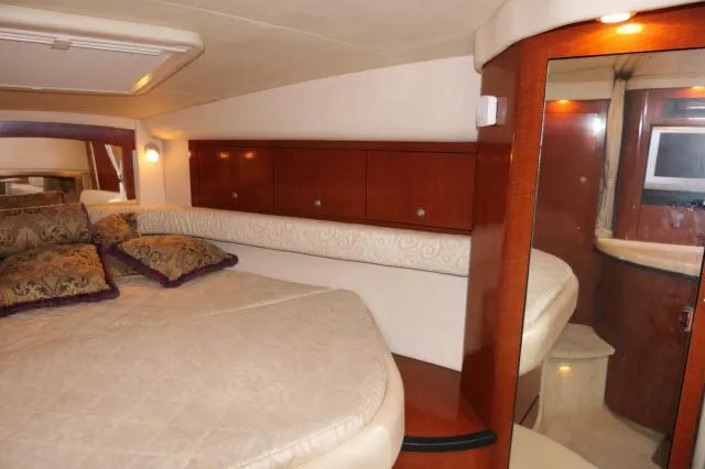 Slide: The Image of Interior of 2005 Sea Ray 340 Sundancer with cozy bed and wooden cabinetry. - 9