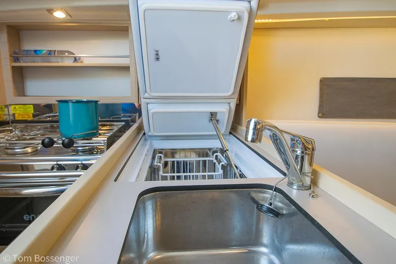 Slide: The Image of Beneteau Oceanis 30.1 2022 yacht kitchen with sink, stove, and open fridge. - 10