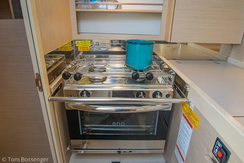 Slide: The Image of Compact kitchen in 2022 Beneteau Oceanis 30.1 yacht with stove and teal pot. - 12