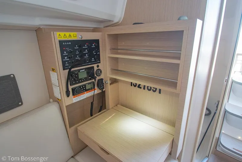 Slide: The Image of Navigation station in 2022 Beneteau Oceanis 30.1 yacht with control panel and storage shelves. - 21
