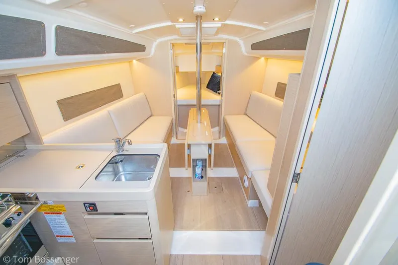 Slide: The Image of Interior of 2022 Beneteau Oceanis 30.1 sailboat with modern kitchen and seating area. - 5