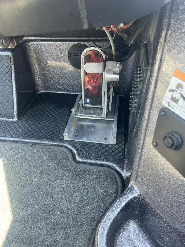 Slide: The Image of Foot pedal in a 2015 Triton 20TRX boat interior, featuring textured flooring. - 16