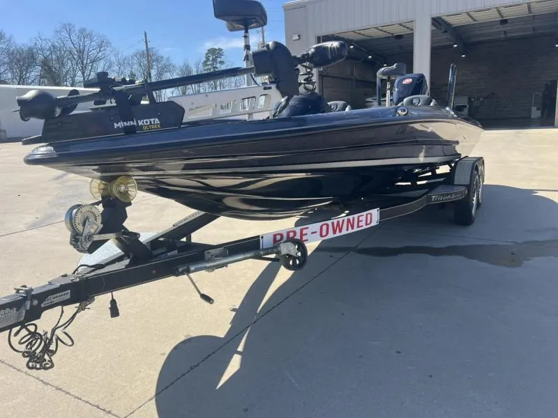 Slide: The Image of 2015 Triton 20TRX boat on trailer, labeled pre-owned, parked outside a building. - 7