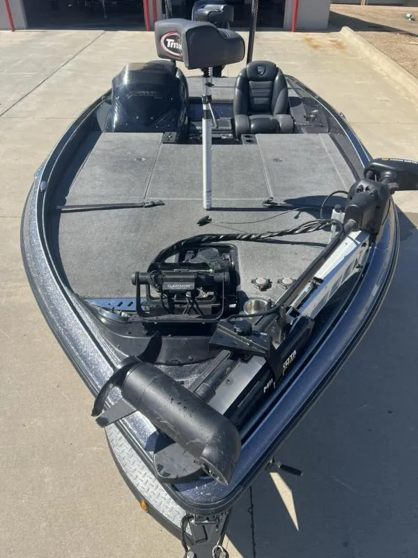 Slide: The Image of 2015 Triton 20TRX fishing boat with trolling motor and seating on concrete surface. - 8