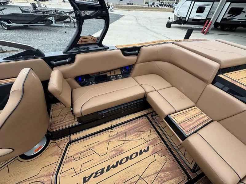 Slide: The Image of 2025 Moomba Max boat interior with tan seating and wood accents. - 13