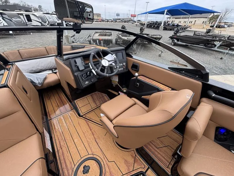 Slide: The Image of 2025 Moomba Max boat interior with tan seats and wood flooring. - 14