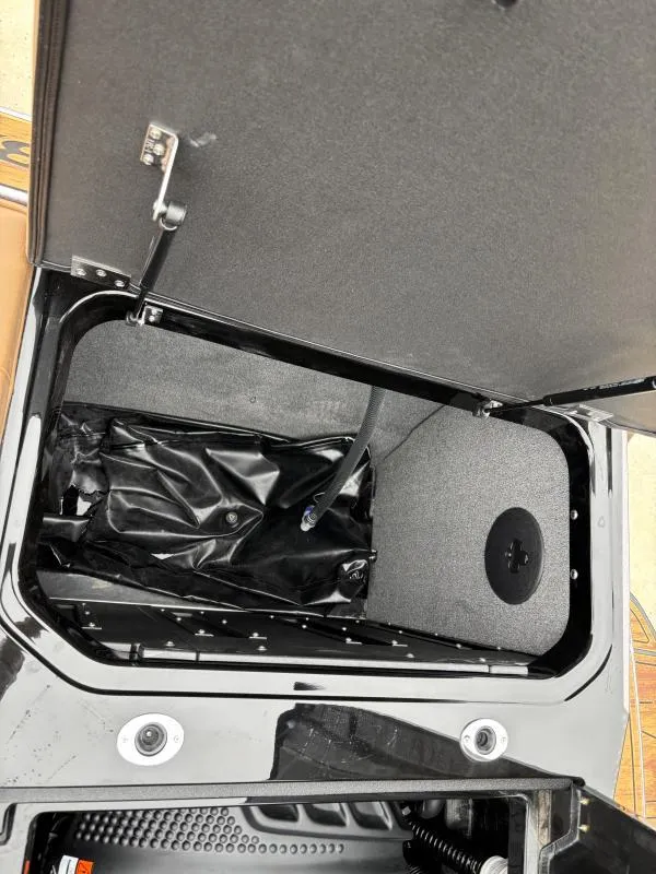 Slide: The Image of 2025 Moomba Max storage compartment with open lid and visible interior details. - 21