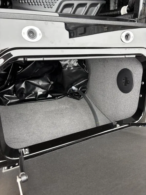 Slide: The Image of 2025 Moomba Max storage compartment with black interior and wiring details. - 23