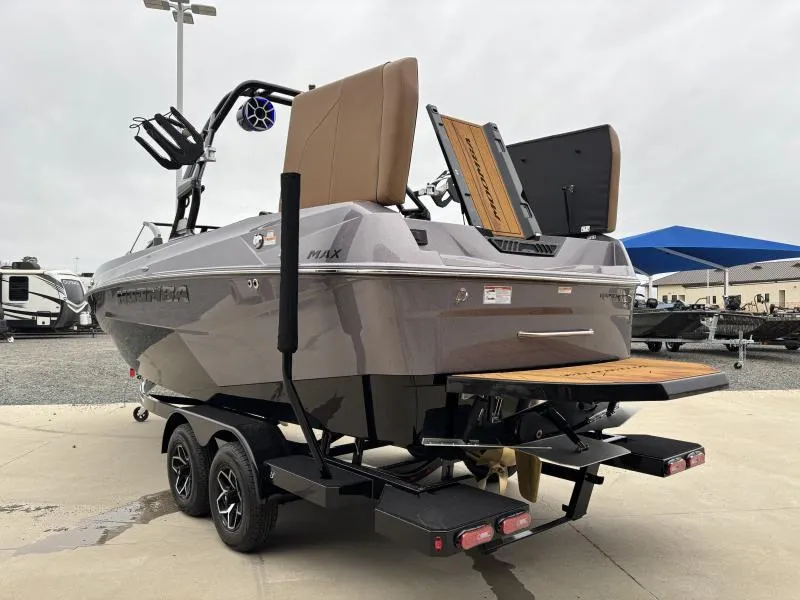 Slide: The Image of 2025 Moomba Max boat on trailer, rear view, showcasing swim platform and wakeboard tower. - 4