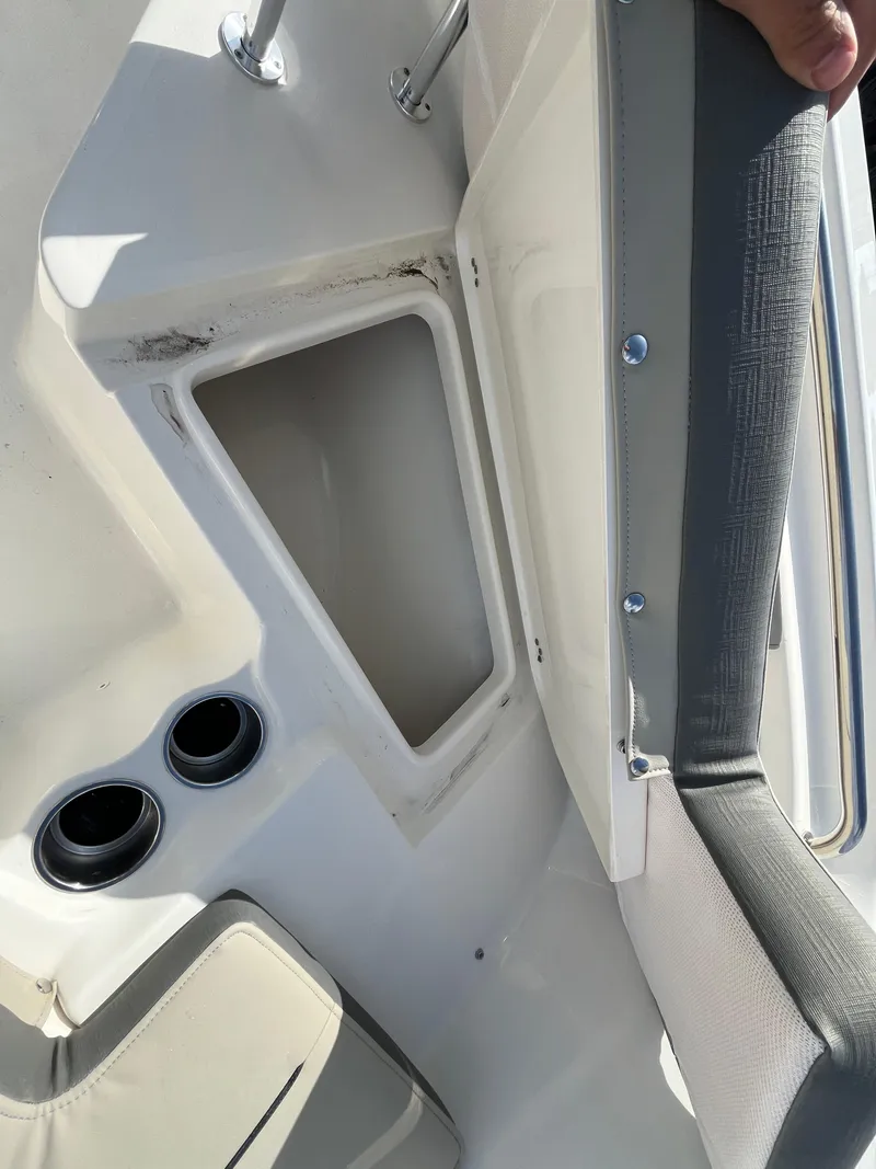Slide: The Image of 2025 Key West 203 FS boat interior with open storage compartment and cup holders. - 12