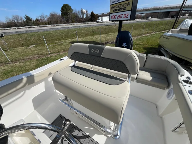 Slide: The Image of 2025 Key West 203 FS boat interior with beige seating and steering wheel. - 14