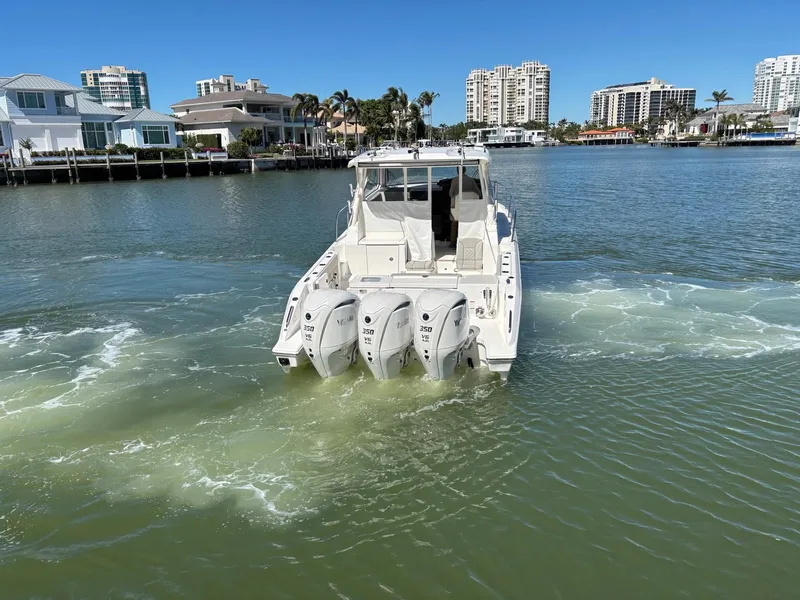 Slide: The Image of 2025 Pursuit OS 355 Offshore boat cruising in a scenic waterfront area. - 10