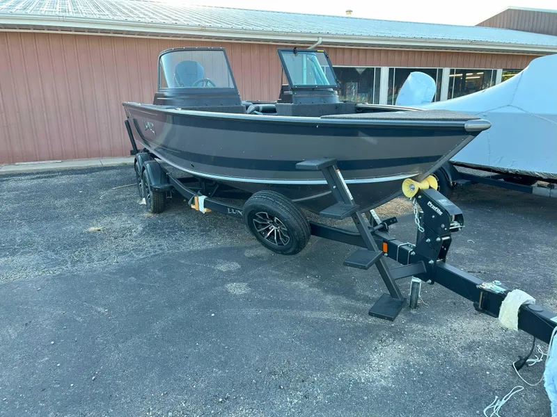 Slide: The Image of 2025 Lund 2075 IMPACT XS boat on trailer, parked outside a building. - 10