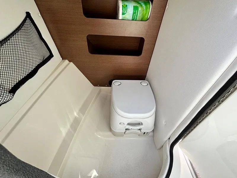 Slide: The Image of Portable toilet in 2016 Sea Ray 240 Sundeck boat cabin with storage shelves. - 11