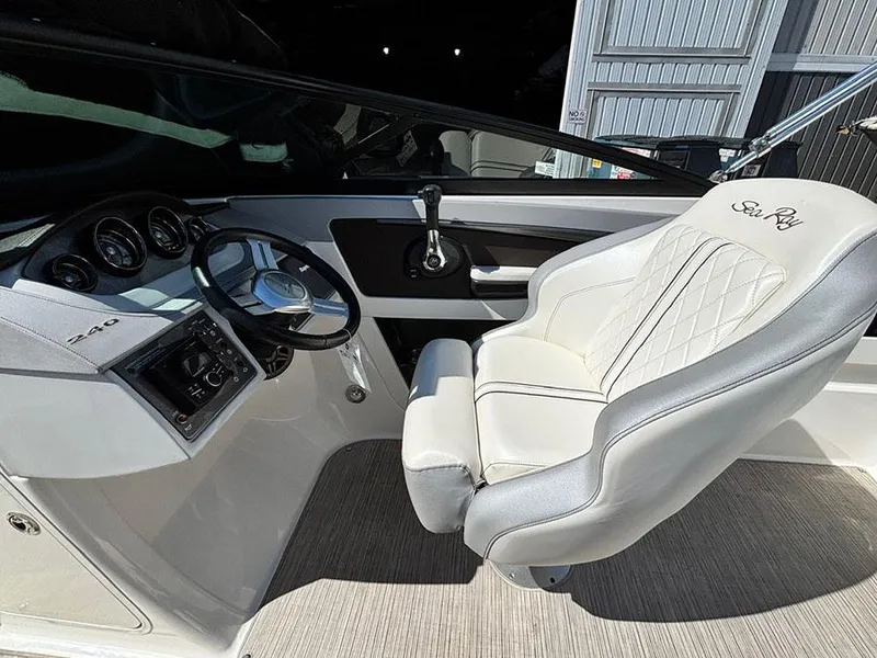 Slide: The Image of 2016 Sea Ray 240 Sundeck cockpit with steering wheel and cushioned captain's chair. - 12