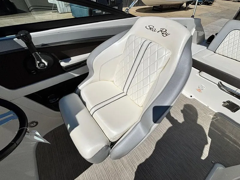 Slide: The Image of Captain's seat of a 2016 Sea Ray 240 Sundeck boat, featuring elegant white upholstery. - 13