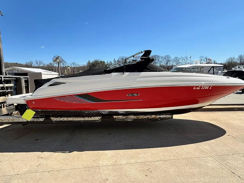 Slide: The Image of 2016 Sea Ray 240 Sundeck boat with red hull on a trailer. - 27
