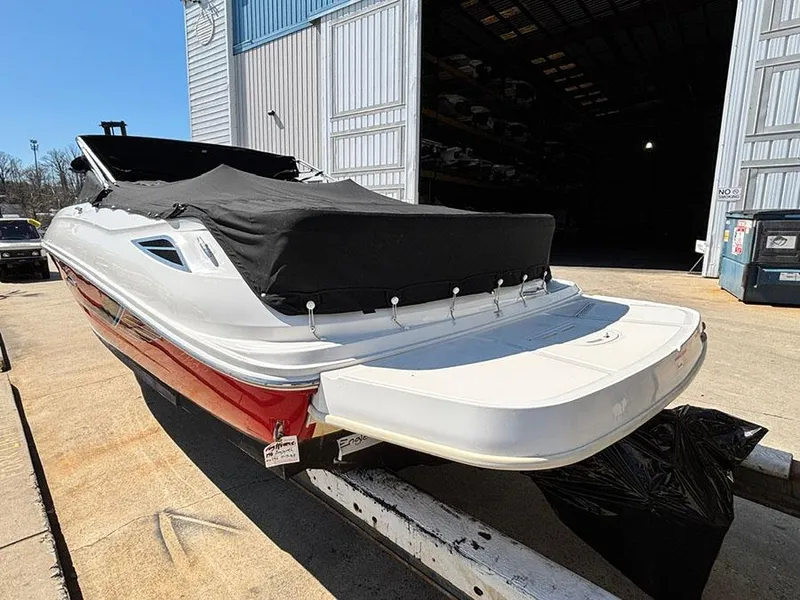 Slide: The Image of 2016 Sea Ray 240 Sundeck boat with cover, docked outside a storage facility. - 4