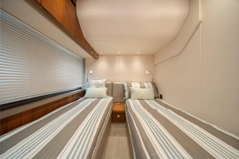 Slide: The Image of Twin beds in a 2020 Sunseeker 52 Manhattan yacht cabin, featuring modern decor. - 20