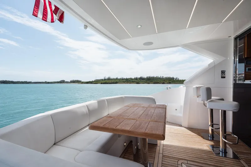 Slide: The Image of Luxurious Sunseeker 52 Manhattan yacht deck with seating, ocean view, and American flag. - 24