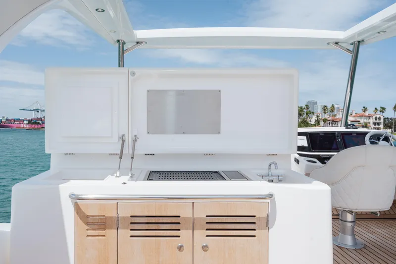 Slide: The Image of Outdoor kitchen on 2020 Sunseeker 52 Manhattan yacht, featuring grill and cabinetry. - 35