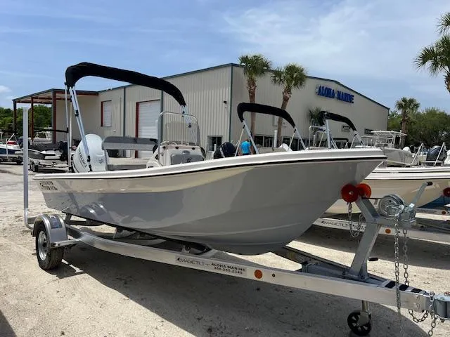 The Image of 2025 Carolina Skiff 178 JLS boat on trailer, parked outside a marine dealership. - 1