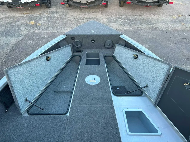 Slide: The Image of 2025 Lund 2075 IMPACT XS boat interior with open storage compartments and speakers. - 6