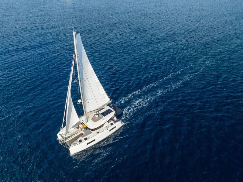 Slide: The Image of Aerial view of 2025 Lagoon 38 catamaran sailing on open blue sea. - 65