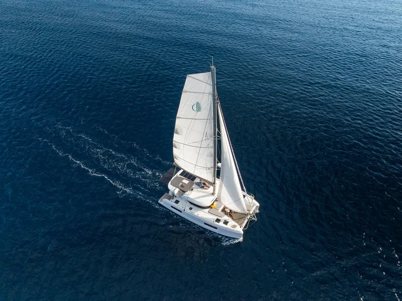 Slide: The Image of Aerial view of 2025 Lagoon 38 sailing on open blue sea. - 69