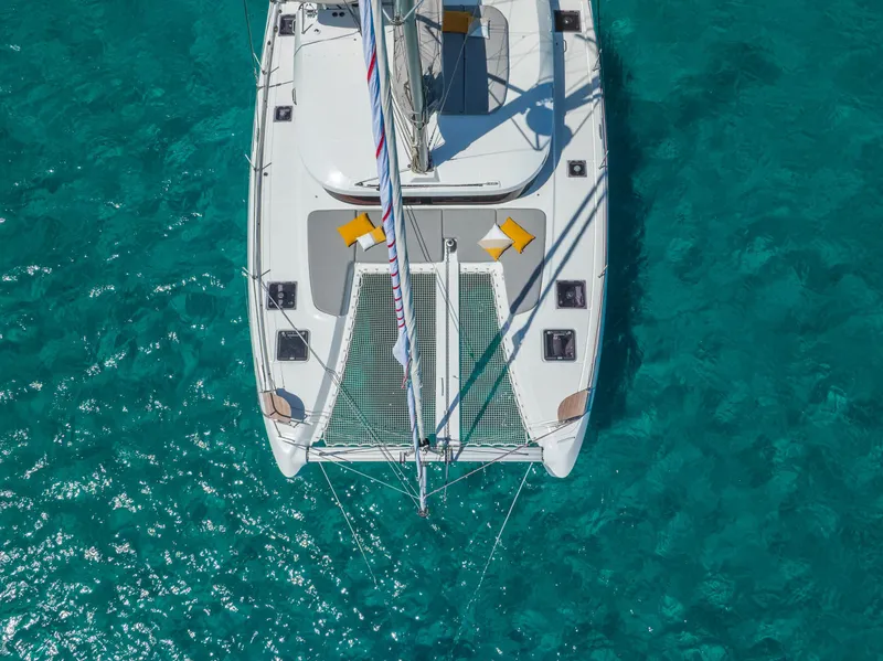 Slide: The Image of Aerial view of 2025 Lagoon 38 catamaran on clear turquoise water. - 7