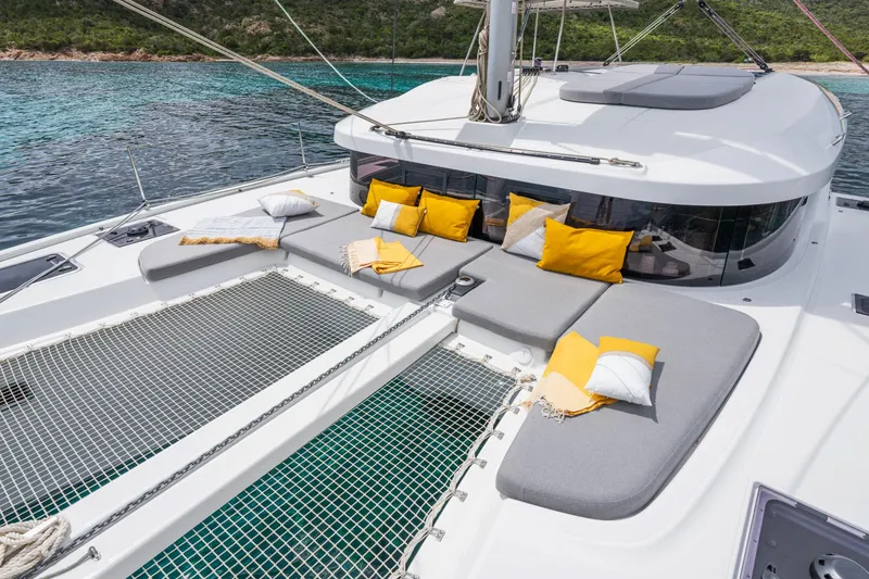 Slide: The Image of Luxurious Lagoon 38 catamaran deck with cushions, 2025 model, anchored in serene waters. - 8