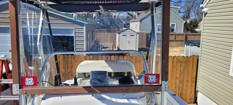 Slide: The Image of 2001 Angler 22 Center Console boat in a residential backyard setting. - 22