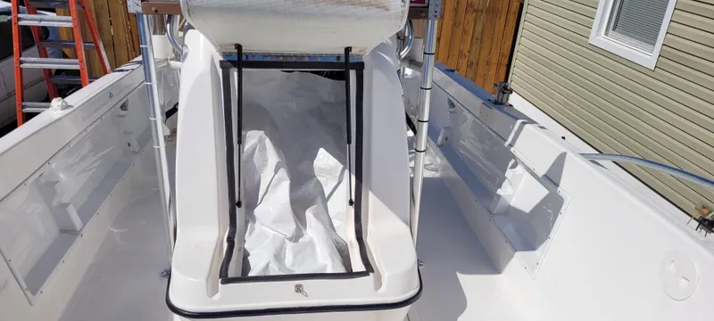 Slide: The Image of 2001 Angler 22 Center Console boat interior with white seating and storage area. - 23