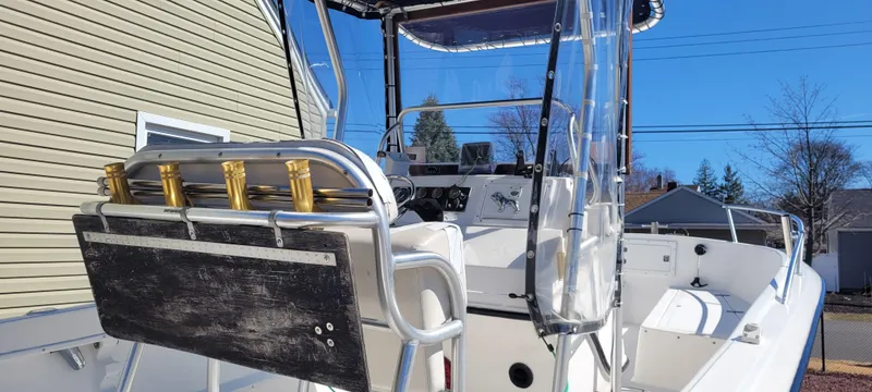 Slide: The Image of 2001 Angler 22 Center Console boat with rod holders and seating, under clear blue sky. - 4