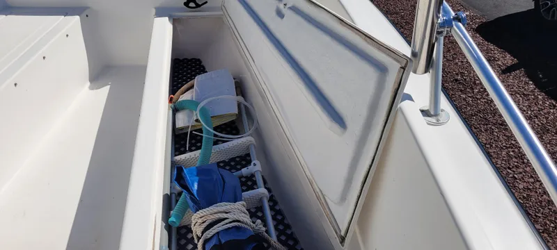 Slide: The Image of Open storage compartment on 2001 Angler 22 Center Console boat with various items inside. - 7