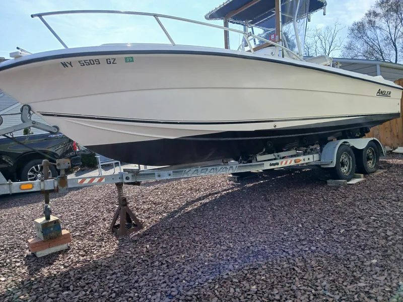 The Image of 2001 Angler 22 Center Console boat on trailer, parked on gravel. - 0