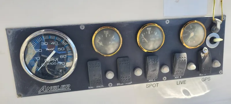 Slide: The Image of Dashboard of a 2001 Angler 22 Center Console boat with gauges and switches. - 11