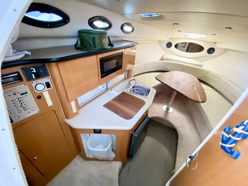 Slide: The Image of 2001 Regal 2660 COMMODORE cabin interior with kitchenette, seating, and portholes. - 12