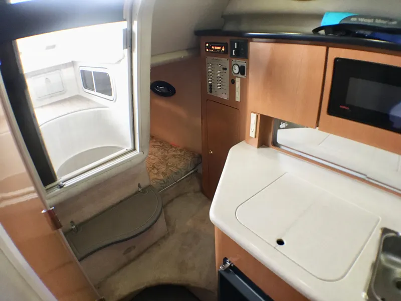 Slide: The Image of Interior of 2001 Regal 2660 Commodore boat with kitchenette and seating area. - 13