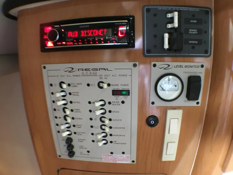 Slide: The Image of Control panel of a 2001 Regal 2660 COMMODORE boat with switches and level monitor. - 16