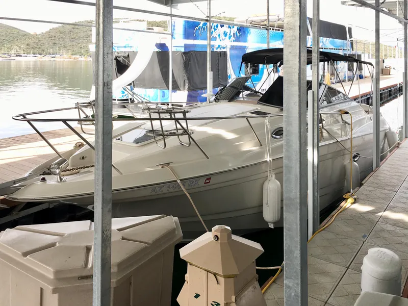 Slide: The Image of 2001 Regal 2660 Commodore boat docked in a marina, surrounded by calm waters. - 2