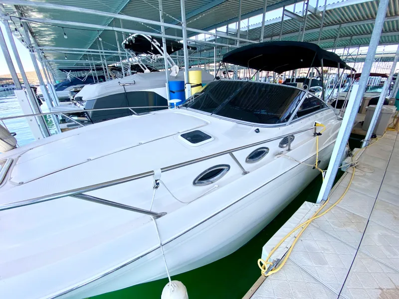 Slide: The Image of 2001 Regal 2660 Commodore boat docked in a marina, featuring sleek design and covered seating. - 22