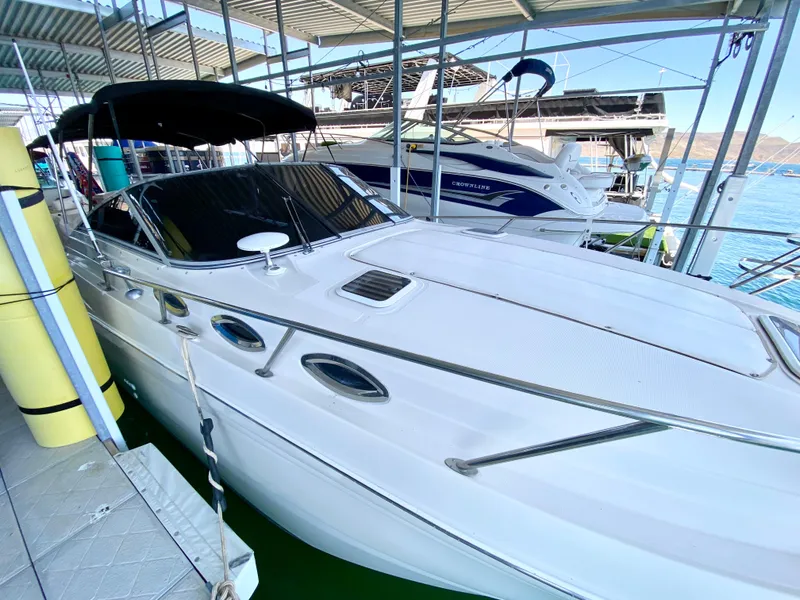 Slide: The Image of 2001 Regal 2660 Commodore boat docked in marina, white exterior, covered canopy. - 23