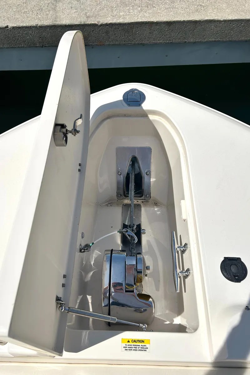 Slide: The Image of 2020 Grady-White Freedom 325 anchor locker with open hatch, showcasing anchor mechanism. - 14