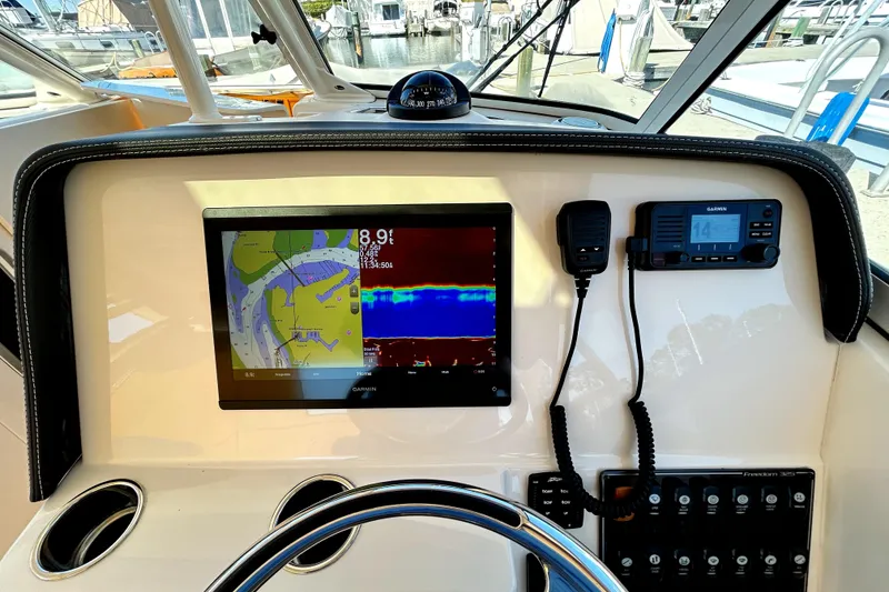 Slide: The Image of Helm of 2020 Grady-White Freedom 325 with navigation display and controls. - 17