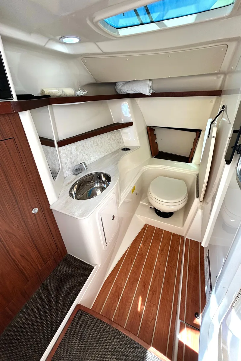 Slide: The Image of 2020 Grady-White Freedom 325 boat interior with wood accents and compact bathroom. - 23
