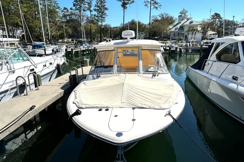 Slide: The Image of 2020 Grady-White Freedom 325 boat docked in a marina, surrounded by other vessels. - 3