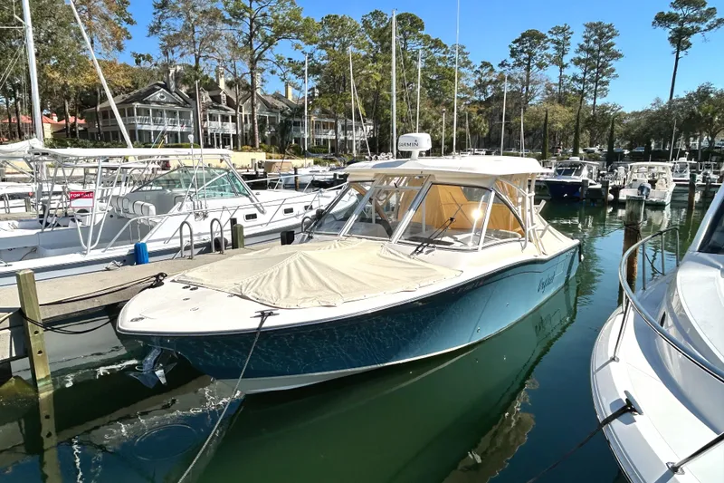 Slide: The Image of 2020 Grady-White Freedom 325 boat docked in a marina with other vessels. - 4