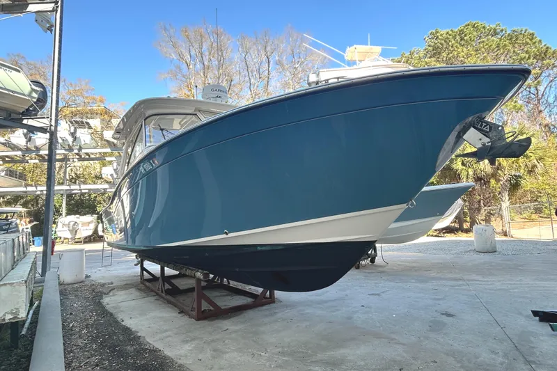 Slide: The Image of 2020 Grady-White Freedom 325 boat on dry dock, blue hull, outdoor setting. - 8